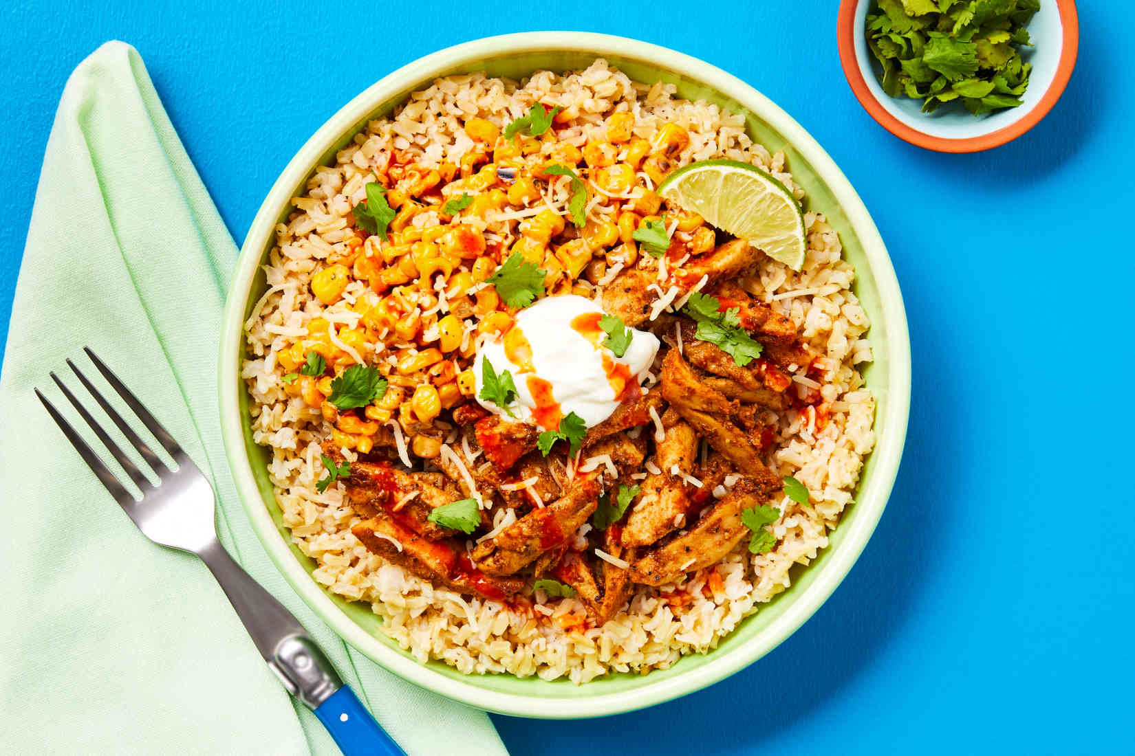 TaqueriaChickenBowlswithBrownRiceCornEsquitesSourCreamHotSauceCilantro Feel